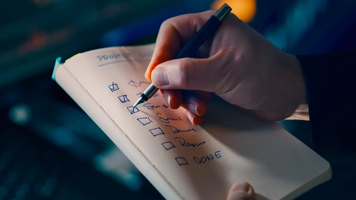 hand checking items on a notebook checklist